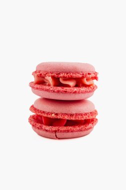 İki canlı kırmızı badem kurabiyesi düzgünce istiflenmiş, hassas dokularını ve kremsi dolgularını sergiliyorlar. Parlak renk bir tatlılık ve zevk hissini davet eder..