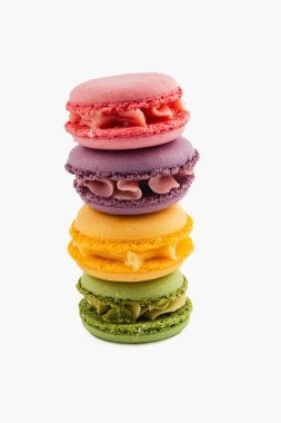 Pembe, mor, sarı ve yeşil renkte dört canlı badem kurabiyesi güzelce istiflenmiş. Her makarna eşsiz dolgusunu sergiler, lezzetli bir ziyafeti davet eder..