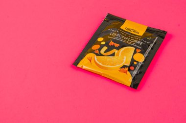 Lviv Ukrayna 05.06.25 canlı sarı arka plan bir paket limon aromalı bitki çayı sergiliyor. Tasarım, canlandırıcı tadını vurgulayan eğlenceli çizimler içeriyor..