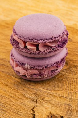 Kremalı iki lavantalı makarna desenli ahşap bir yüzeye oturmuş, zarif renklerini ve zarif görünümlerini sergiliyorlar, tatlı aşıkları için mükemmel..