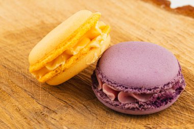 İki canlı makarna güzel bir şekilde sade ahşap bir tahtanın üzerinde düzenlenmiştir. Narin dokularını ve neşeli renklerini sergilerler. Tatlıları sevenler için mükemmeldir..