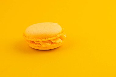 Tek bir sarı badem kurabiyesi, zarif dokusunu ve kremsi dokusunu sergiliyor, tatlı ve davetkar doğasını vurguluyor..