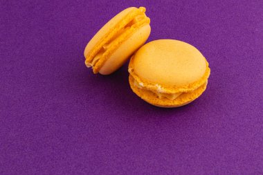 Pürüzsüz dokularını ve kremsi dokularını sergileyen iki sarı badem kurabiyesi, büyüleyici bir görsel tedavi yaratıyor..