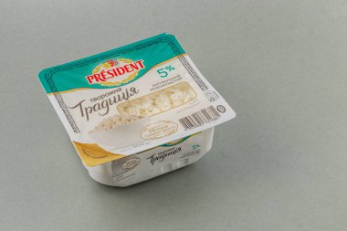 Lviv Ukrayna 05.22.25 Bir süt ürünü paketi gri bir yüzeyde duruyor, beyaz kremsi dokusunu sergiliyor. Paketleme özellikleri farklı etiketleme ve damgalama ögeleri.