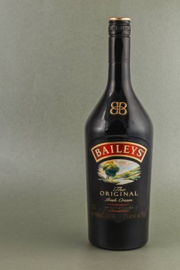 Bir şişe siyah Baileys İrlanda krem likörü açık gri arka planda duruyor, eşsiz etiketini ve pürüzsüz tasarımını sergiliyor. Kutlama toplantıları için ideal..