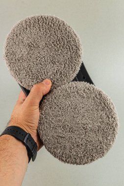 Lviv Ukrayna 05.19.25 Bir kişi, etkili toz alma ve temizleme yüzeyleri için tasarlanmış iki yuvarlak mikrofiber pedi içeren bir el bilgisayarı tutuyor..