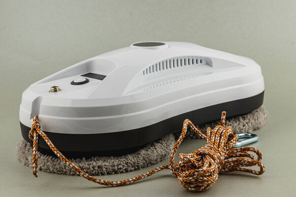 Lviv Ukraine 05.19.25 A compact electric floor cleaning device with a cloth pad and rope is displayed against a neutral background, showcasing its design for easy home cleaning tasks.
