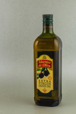 Lviv Ukrayna 05.22.25 Bir şişe ekstra bakir zeytinyağı seçkin bir etiketle ayakta duruyor ve birinci sınıf kalitesini gösteriyor. Ürünün detaylarını vurgulayan ayar tarafsızdır..