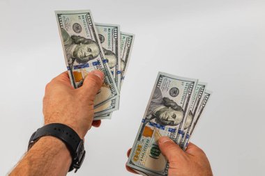 İki el para sayarken farklı banknotlar tutar. Para birimi açıkça görülüyor, detaylarını ve tasarımını gösteriyor..