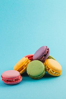 Değişik renk ve aromalı makaronların hoş çeşitleri canlı mavi bir arka plana karşı sergileniyor, narin dokularını ve şekillerini sergiliyorlar..