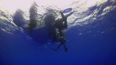 Pasifik Okyanusu, Kosta Rika - 5 Eylül 2021: Bir grup profesyonel dalgıç temiz ve ışıltılı su yüzeyinin arka planında dinleniyor.
