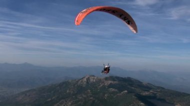 Fethiye, Türkiye - 14 Eylül 2017: Mavi gökyüzü ve bulutların arka planında paragliding. Aktif eğlence, ekstrem spor ve turizm kavramı.