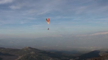 Fethiye, Türkiye - 14 Eylül 2017: Mavi gökyüzü ve bulutların arka planında paragliding. Aktif eğlence, ekstrem spor ve turizm kavramı.