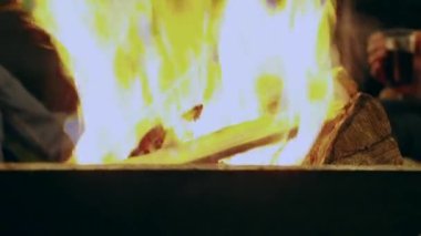 Ağır çekim, odun yığınına çok yakın çekim. Ocakta gece parlak bir şekilde yanıyor.