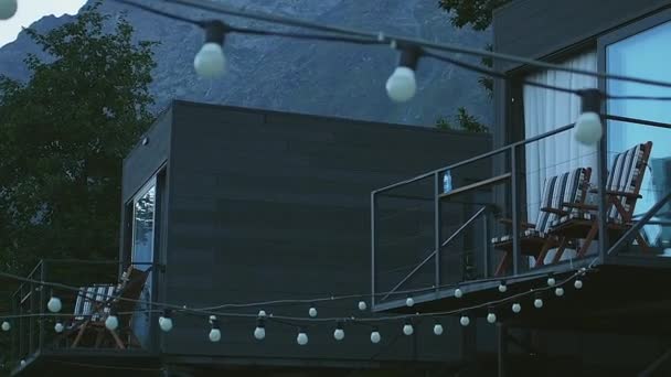 在日出时开着夜灯的山酒店 背景是岩石山 — 图库视频影像