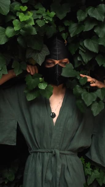 Model Groen Linnen Kimono Zwart Lederen Masker Poseert Een Bos — Stockvideo