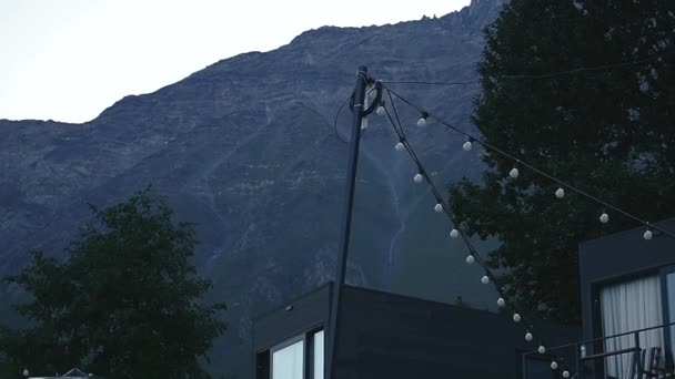 Ein Berghotel Mit Pavillons Und Laternen Bei Sonnenaufgang Vor Bergkulisse — Stockvideo