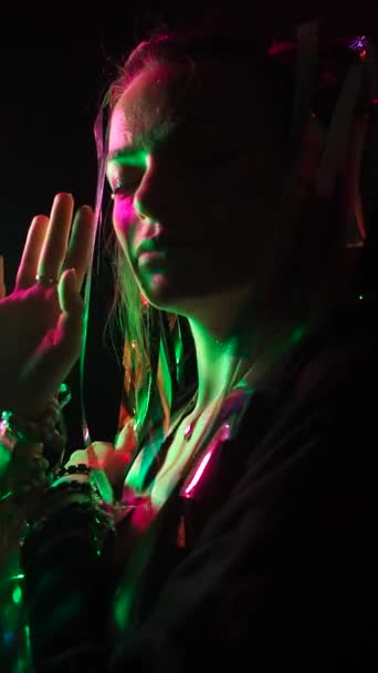 輝く少女は赤と緑のネオンライトで照らされた彼女の髪のフィルムで顔 — ストック動画