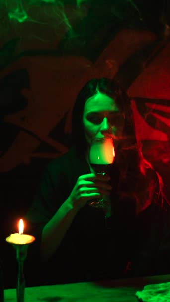 Uma Bruxa Com Olho Vidro Bebe Fumaça Copo Uma Mesa — Vídeo de Stock