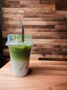 Bir bardak kibrit yeşil çay güzel desenli ahşap bir masaya konur..