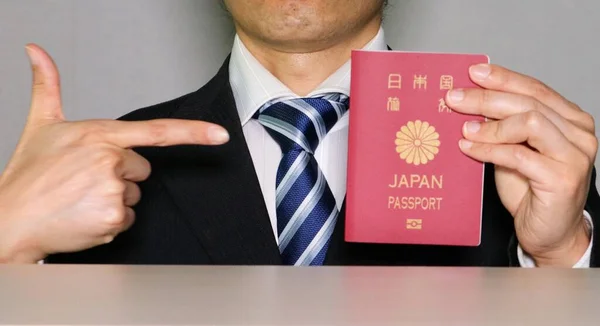 İş adamı Japon pasaportunu işaret ediyor