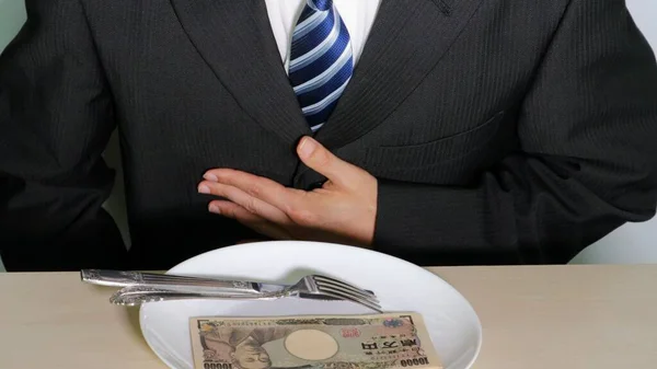 Lüks bir yemeğin önünde poz veren bir iş adamı.