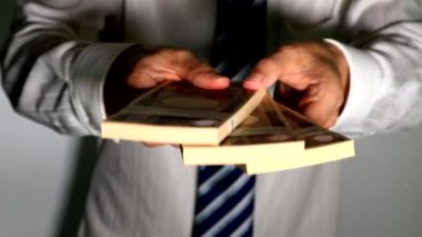 Bir tomar banknot teslim eden bir iş adamı.