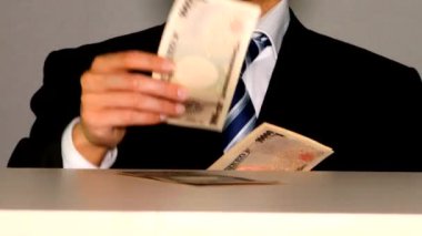 İşadamı banknotları masaya koyuyor.