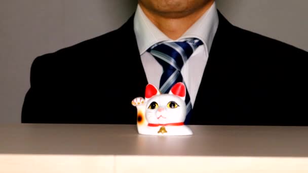 一个商人在一只招呼客人的猫面前做礼拜 — 图库视频影像
