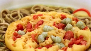 Hazır tempura soba yemeye çalışan biri.