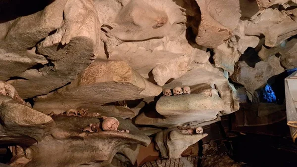 그라비아드 하나에 인간의 두개골 두개골의 더미와 사슬이 동굴에 배치되거나 절벽에서 — 스톡 사진