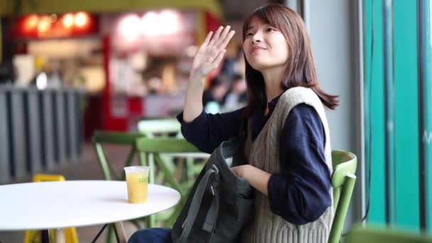Asiático Chinês Mulher Cumprimenta Sorrindo Olhando Para Câmera Enquanto Espera — Vídeo de Stock