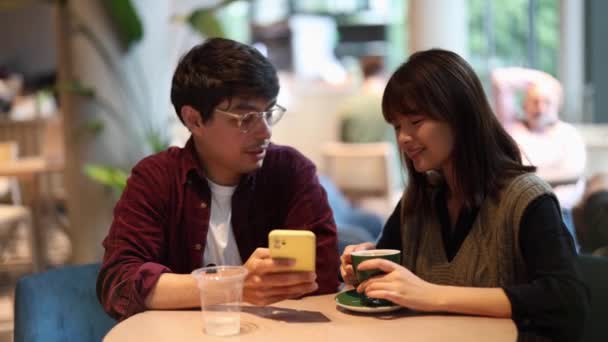 カフェテリアでコーヒーを飲む友人のカップルは 笑顔で自分撮りをしている — ストック動画