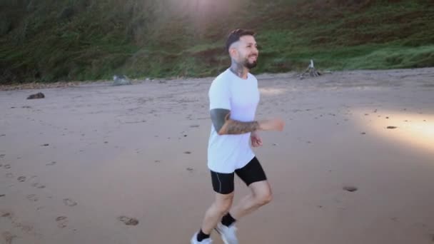 Молодий Дорослий Спортивний Чоловік Біжить Сході Сонця Пляжі Видом Гори — стокове відео