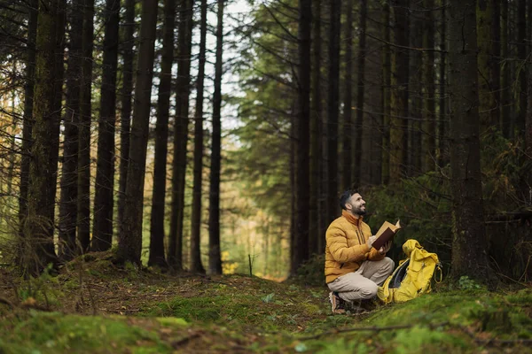 Mladý Dospělý Muž Batohem Lese Mezi Stromy Zastaví Psát Číst — Stock fotografie