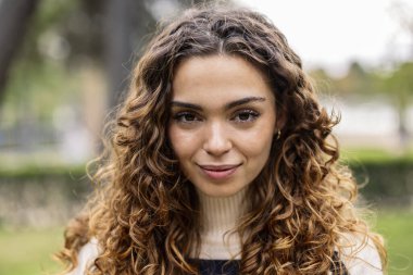 Kameraya bakan güzel kıvırcık saçlı kadının portresi.