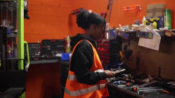 Afro Amerikalı Kadın Makine Mühendisi Atölyesindeki Aleti Seçiyor Kameraya Bakıyor — Stok video
