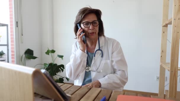 资深女医生在电话远程预约会诊中与病人交谈 — 图库视频影像