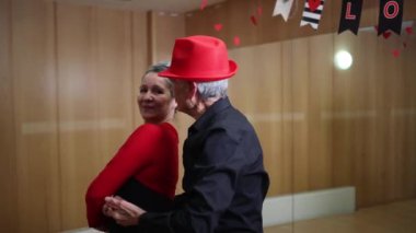 Yaşlı çift emeklilik atölyesinde klasik Latince dans adımları öğreniyor.