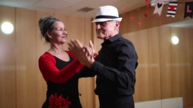 Balo salonundaki dans atölyesinde dans eden yaşlı çift.