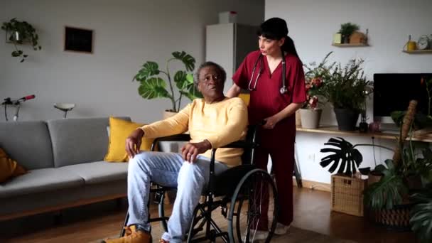 Verzorger Verpleegkundige Duwt Oudere Afro Amerikaanse Man Rolstoel Hem Leren — Stockvideo
