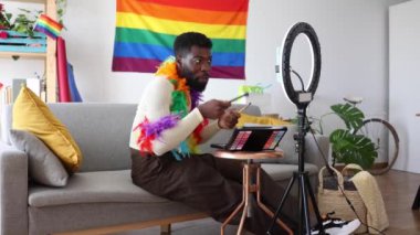 Genç Afro-Amerikan erkek drag queen evde akıllı telefonlar eşliğinde çevrimiçi makyaj dersi kaydediyor- LGBT, çift cinsiyetli olmayan