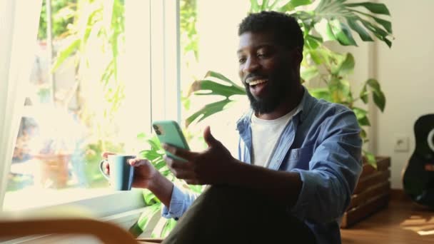 Ung Afroamerikansk Vuxen Får Goda Nyheter Sin Telefon Och Firar — Stockvideo