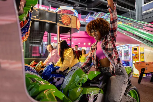 Αφροαμερικανή Έφηβη Γιορτάζει Νίκη Στον Αγώνα Arcade Μοτοσικλέτας Τους Πολυεθνικούς Φωτογραφία Αρχείου
