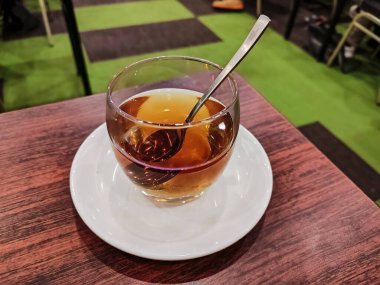 Bir bardak sıcak çay servis masasında demlenmiş bir bira..