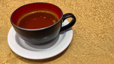 Bir bardak sıcak çay servis masasında demlenmiş bir bira..