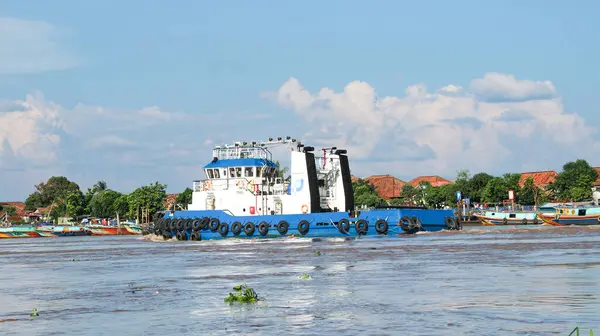 stock image  tugboat pulling a heavily laden barge sailing on the Musi River.