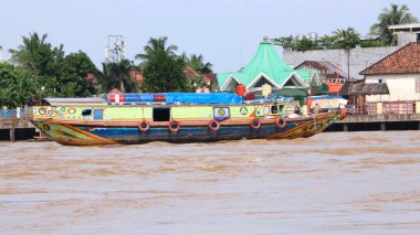 Palembang, Endonezya - 30 Mayıs 2024: Musi Nehri 'nde mal taşıyan tekneler. Güney Sumatra, Endonezya 'daki Palembang şehrindeki ünlü nehir..