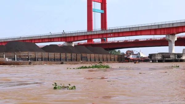 stock image Palembang, Indonesia - May 31, 2024: tugboat pulling a heavily laden coal barge exploring the Musi River in Palembang.