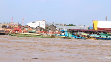 Palembang, Endonezya - 30 Mayıs 2024: Musi Nehri 'nde mal taşıyan tekneler. Güney Sumatra, Endonezya 'daki Palembang şehrindeki ünlü nehir..